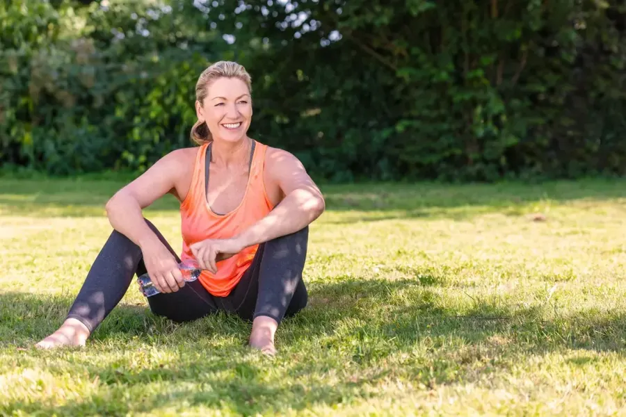 A woman resting on the grass after a workout